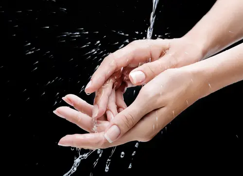 Frauenhände, die unter fließendem Wasser gewaschen werden